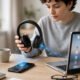Bluetooth headphones next to a smartphone and laptop