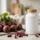 Rosabella beetroot supplement bottle with fresh beetroots and red capsules